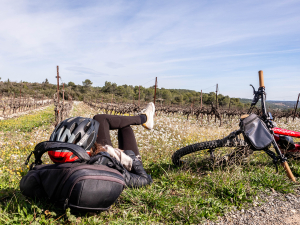 Jeune fille en pause en mode sieste dans les vignes avec son VTT