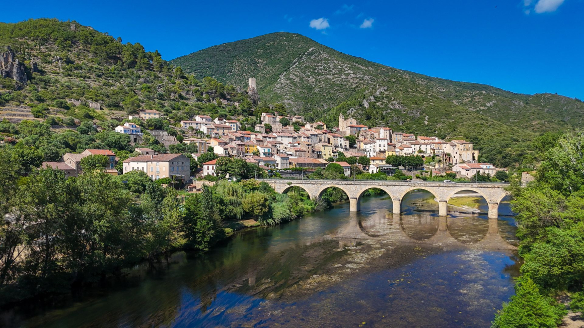 Vue sur le village médiéval de Roquebrun, son pont, sa tour carolingienne et le fleuve Orb