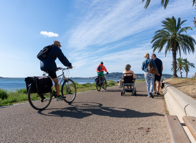 Des personnes en vélo, fauteuil roulant, et en marchant se balade sur la promenade Spinosi-Brassens à Balaruc-les-Bains.