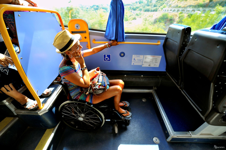Tourisme-Handicap_-_EXCLUSIF_ADT34_Xavier_Quentien_66 Une jeune femme en fauteuil utilise un bus pour se déplacer. La place adaptée se situe derrière le chauffeur.