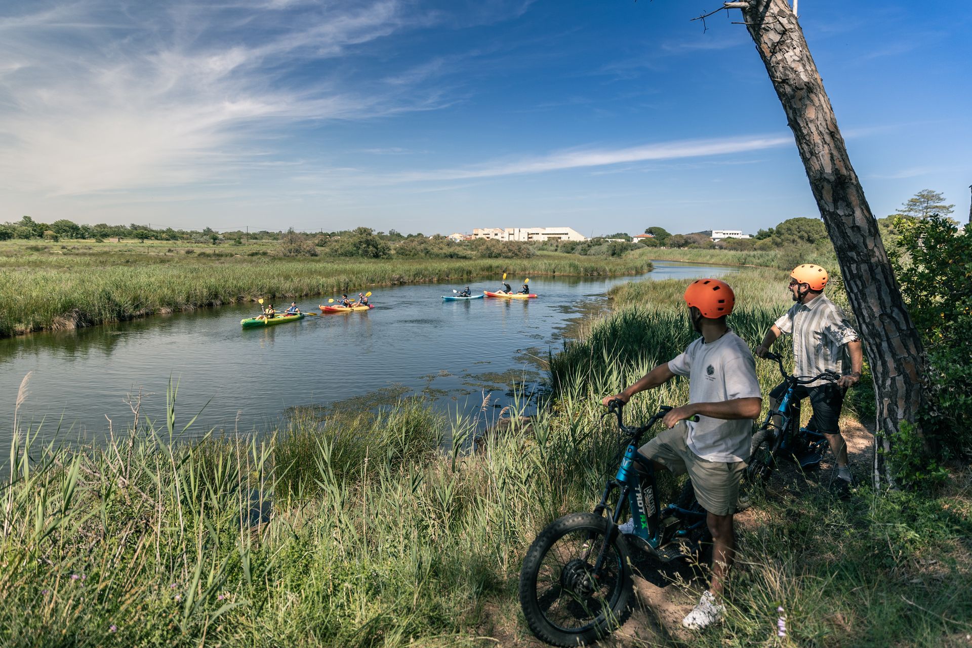 Etang du Clôt © Olivier Octobre Deux personnes en trottinettes électriques regardent un groupe de personnes en canoë-kayak sur l'étang du Clôt