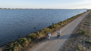Une famille se balade à vélo le long de l'étang de l'Arnel à Palavas-Les-Flots