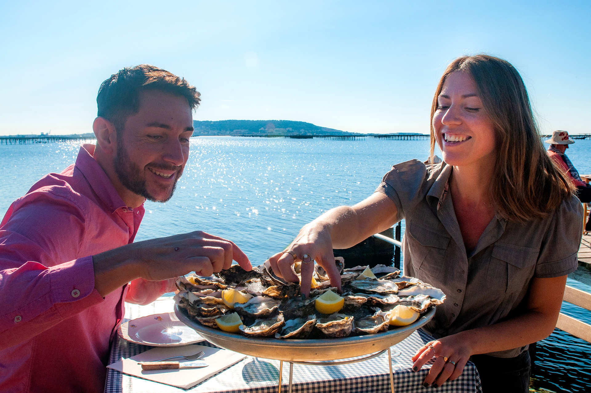 Couple qui déguste des huitres dans un mas conchylicole au bord de l'étang de thau
