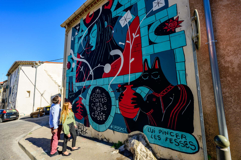 Couple qui regarde une fresque street art du MACO à Sète
