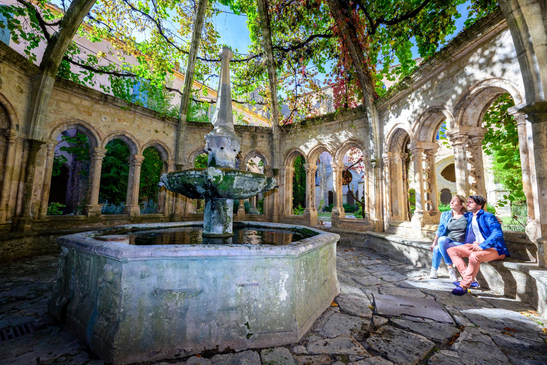 Un couple en admiration devant la fontaine de l'abbaye de Valmagne située dans l'Archipel de Thau