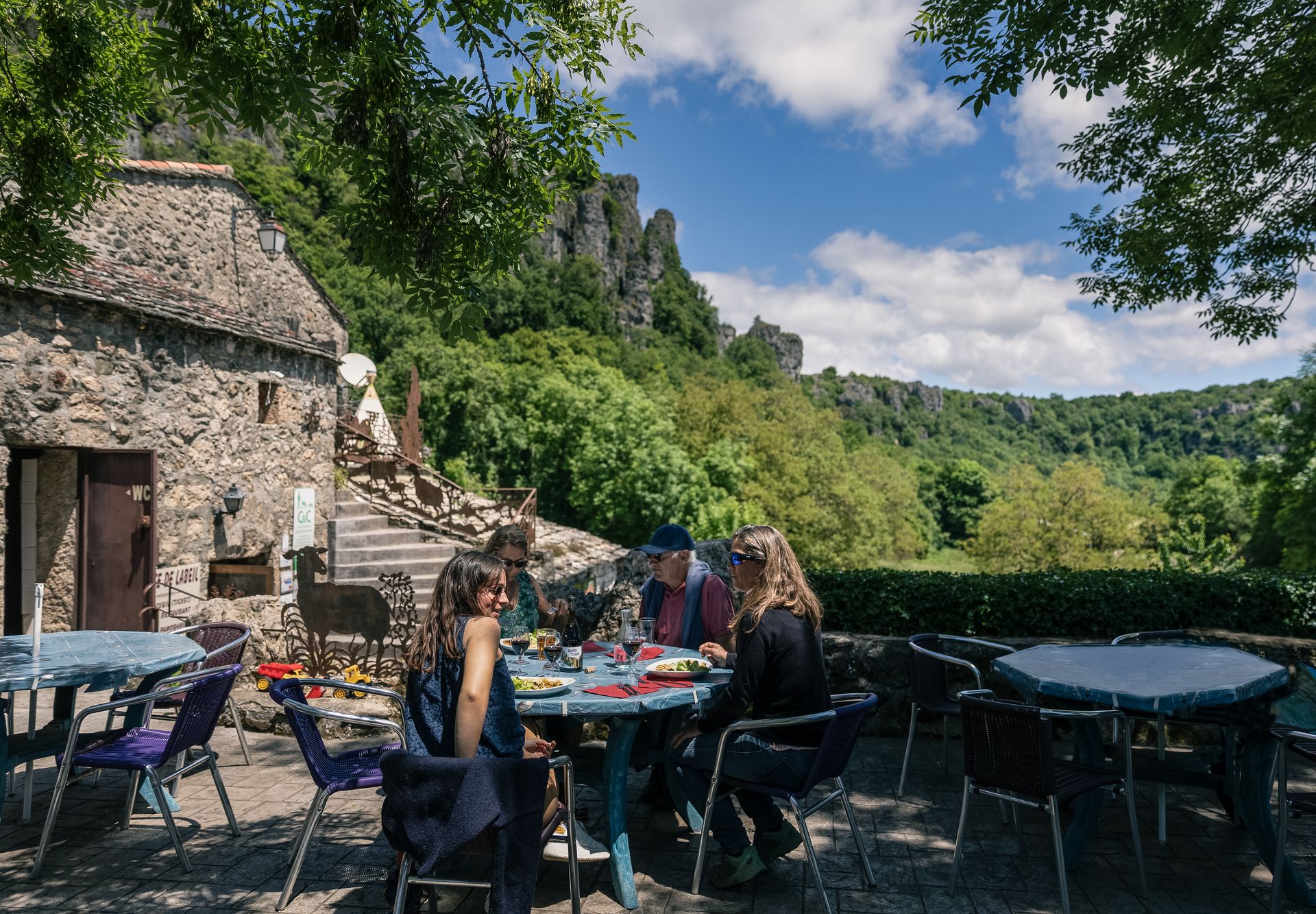 Des amis déjeunent sur la terrasse du restaurant de la grotte de Labeil