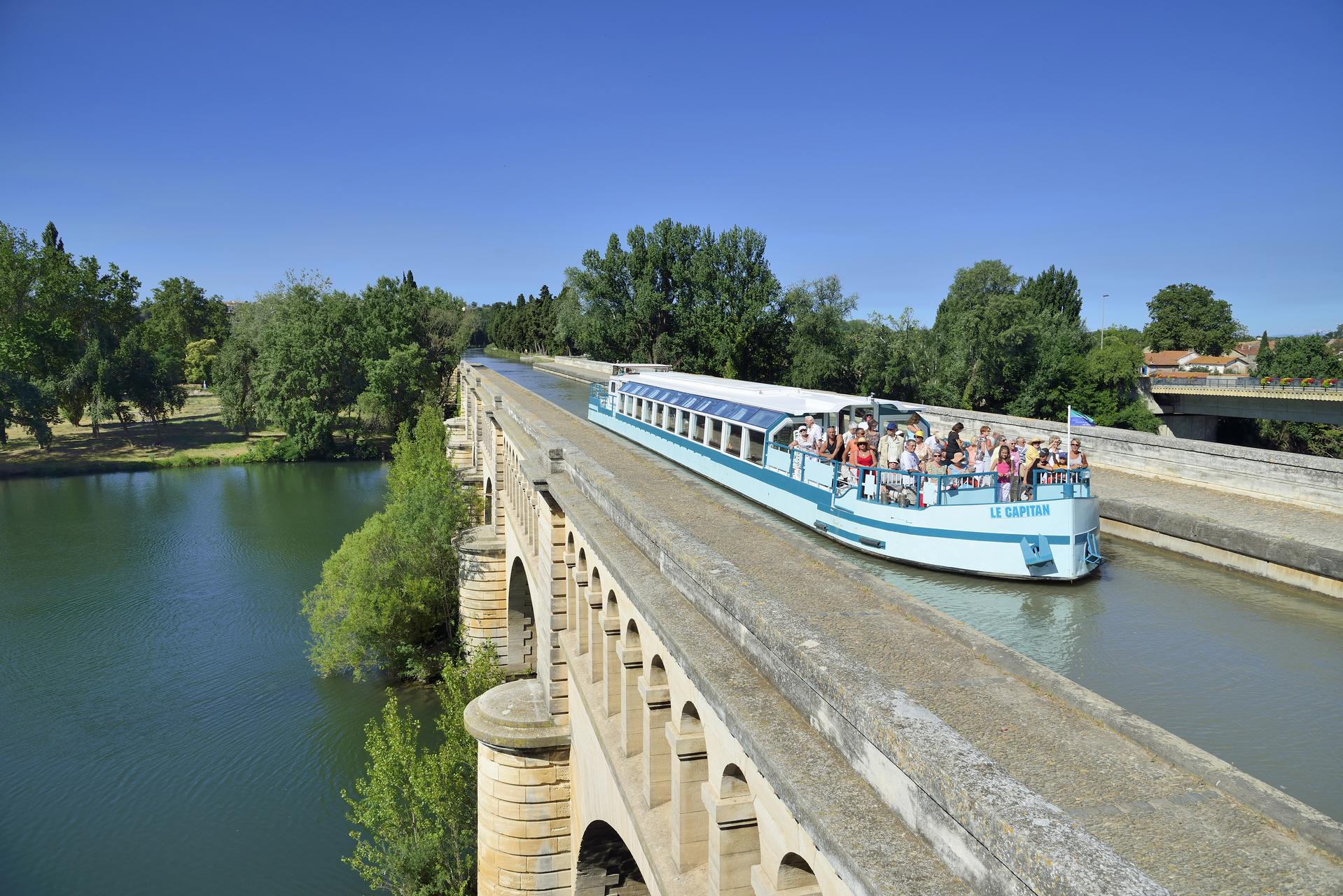 Canal du Midi, classé Patrimoine Mondial de l'UNESCO. Pont Canal, péniche touristique franchissant le fleuve Orb
