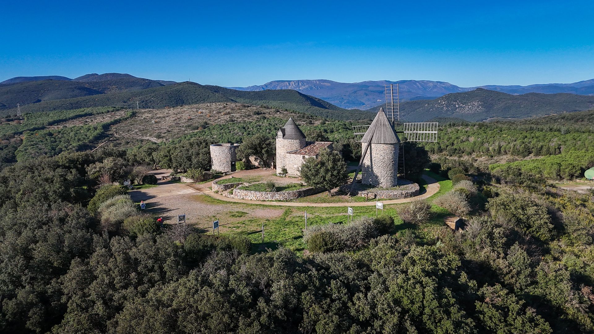 Les moulins de Faugères dans les avant-monts avec, en arrière-plan, vue sur les montagnes du Haut-Languedoc