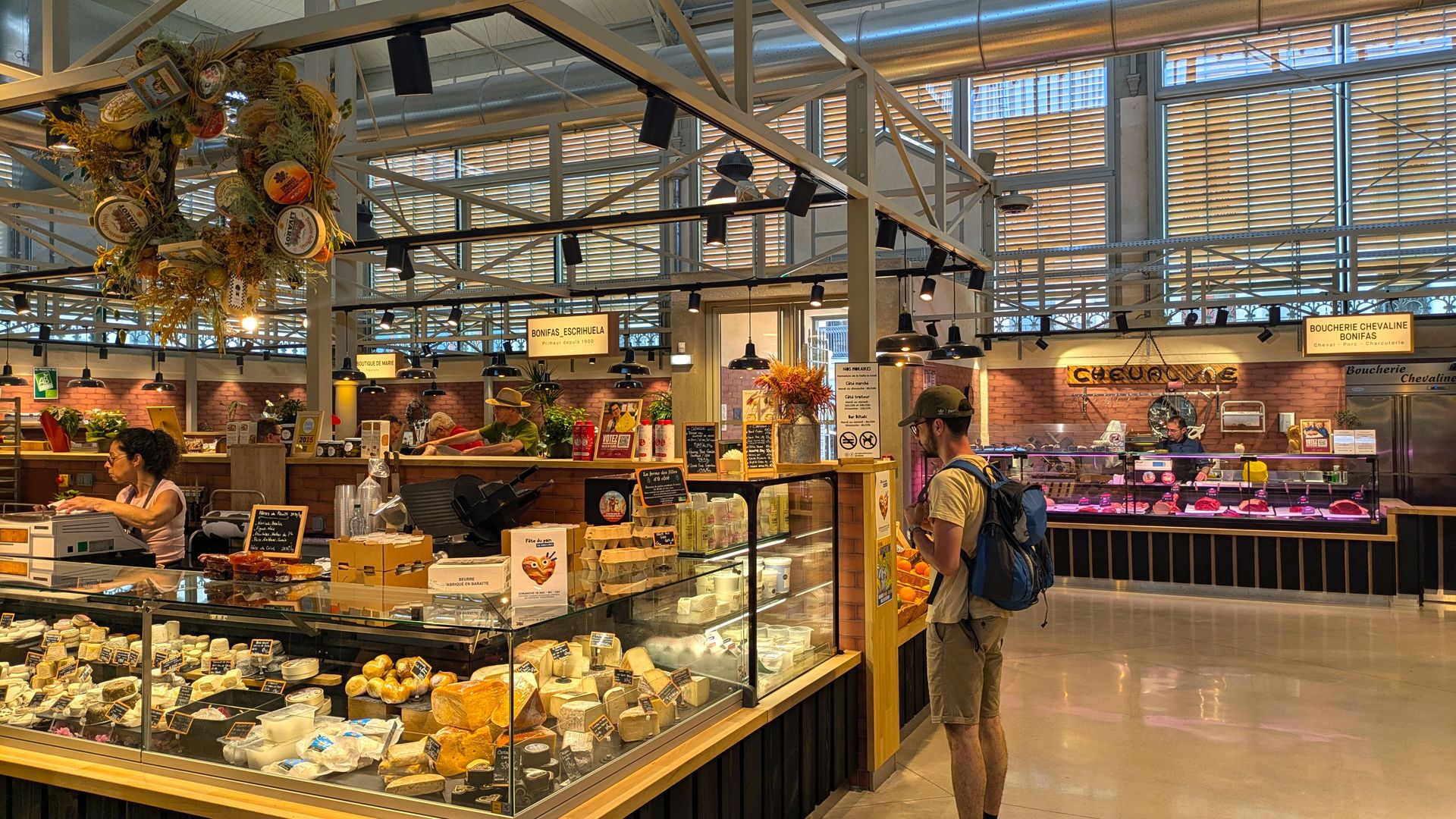 Homme devant l'étal d'un fromager à l'intérieur des halles Biltoki de Béziers entièrement rénovées
