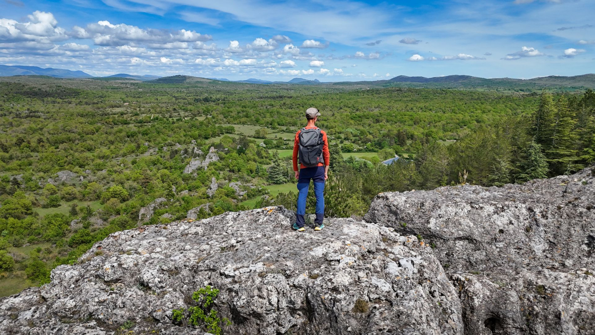 David Genestal, blogueur de Carnets de Rando, admire le panorama sur les espaces sauvages du Larzac Méridional depuis le Roc Castel au Caylar