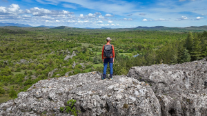 David Genestal, blogueur de Carnets de Rando, admire le panorama sur les espaces sauvages du Larzac Méridional depuis le Roc Castel au Caylar