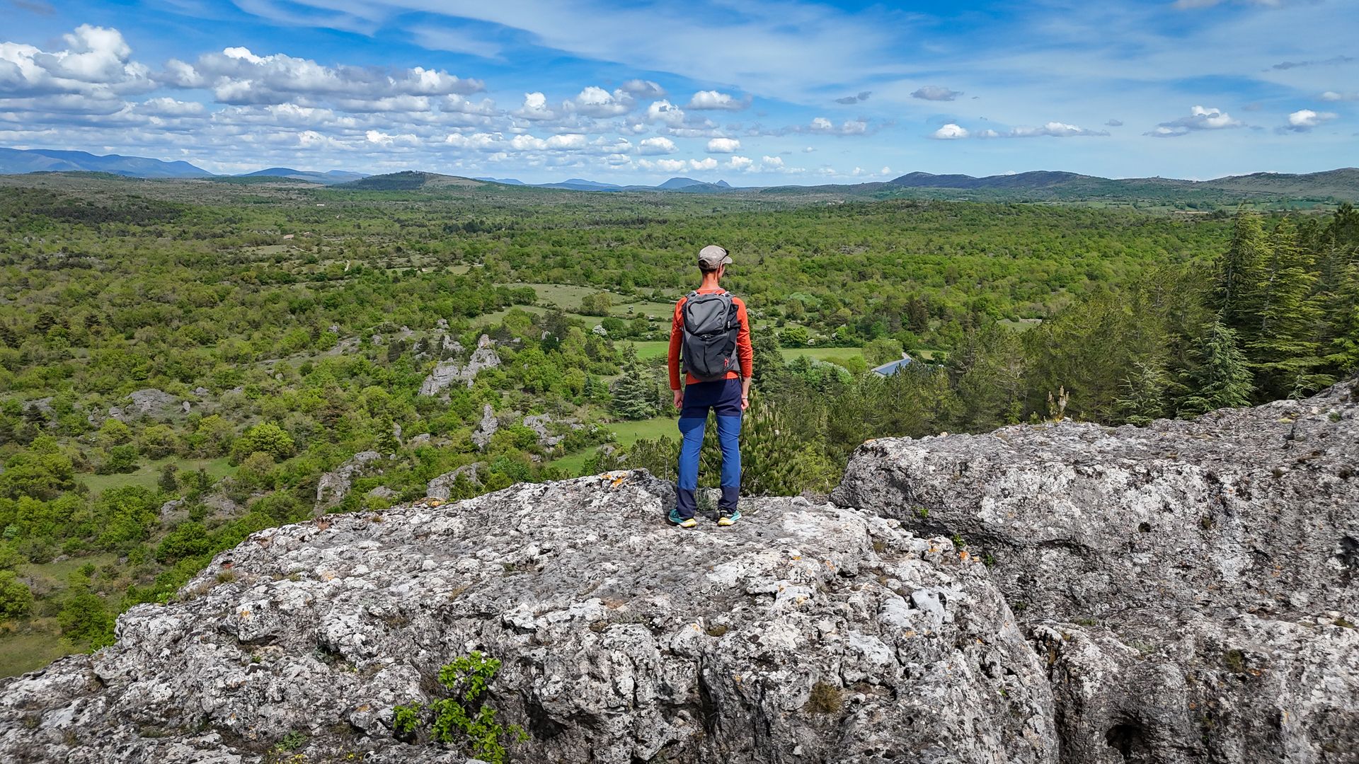 David Genestal, blogueur de Carnets de Rando, admire le panorama sur les espaces sauvages du Larzac Méridional depuis le Roc Castel au Caylar
