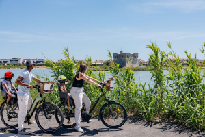 Une famille en balade à vélo s'arrête pour admirer la Redoute de Ballestras à Palavas-Les-Flots